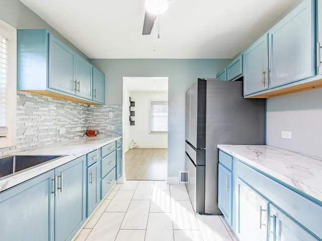 a kitchen with a sink refrigerator and cabinets