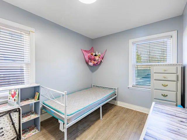 a room with a bed and a wooden floor