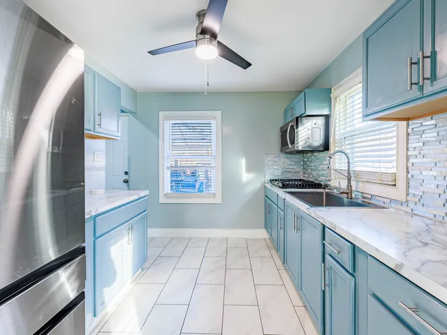 a kitchen with granite countertop a sink and a stove