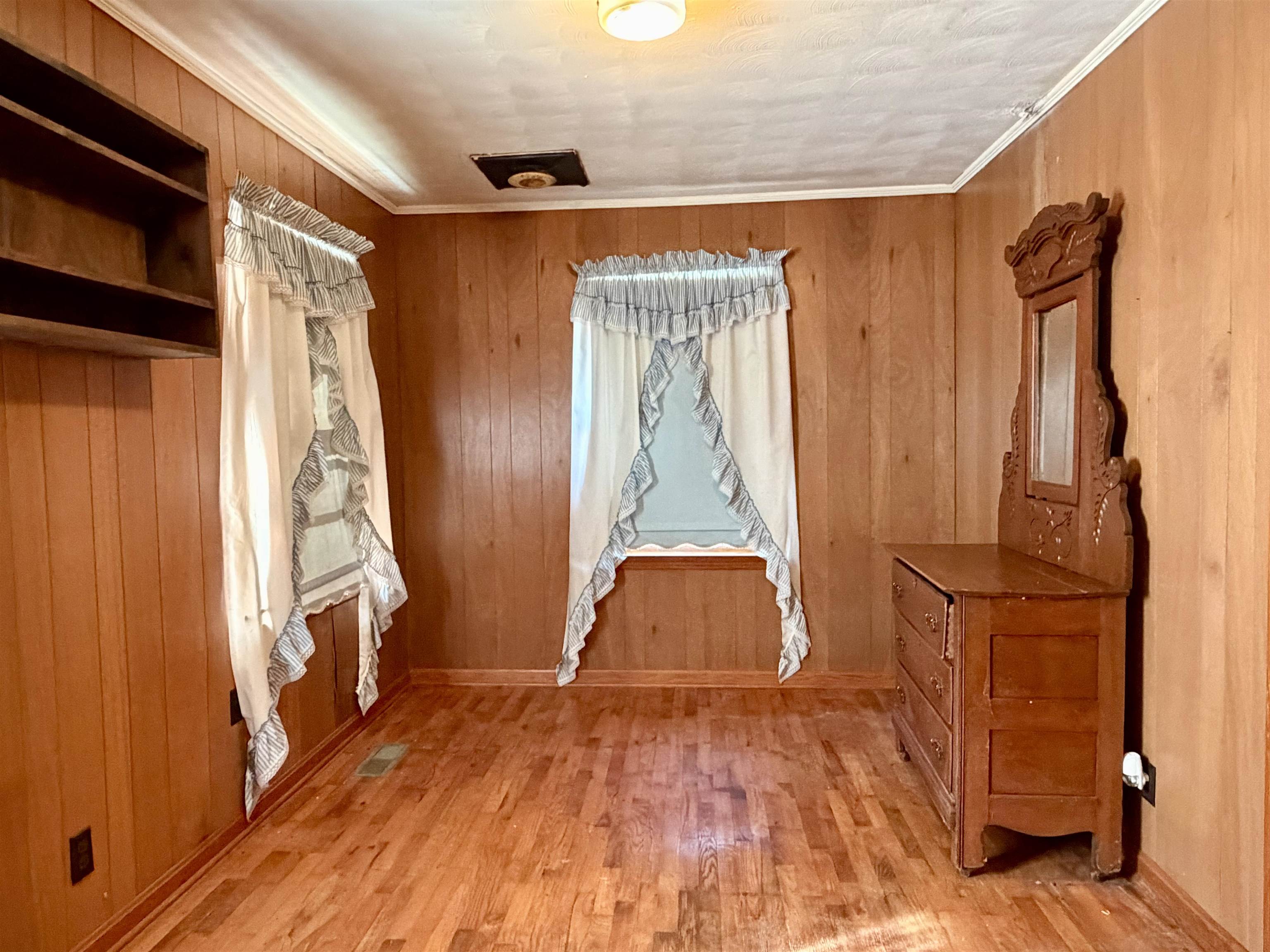 218 Sardie Henry Road Bethel Springs, TN 38315 - Photo 11 of 18 Unfurnished bedroom with light wood finished floors, wood walls, and ornamental molding