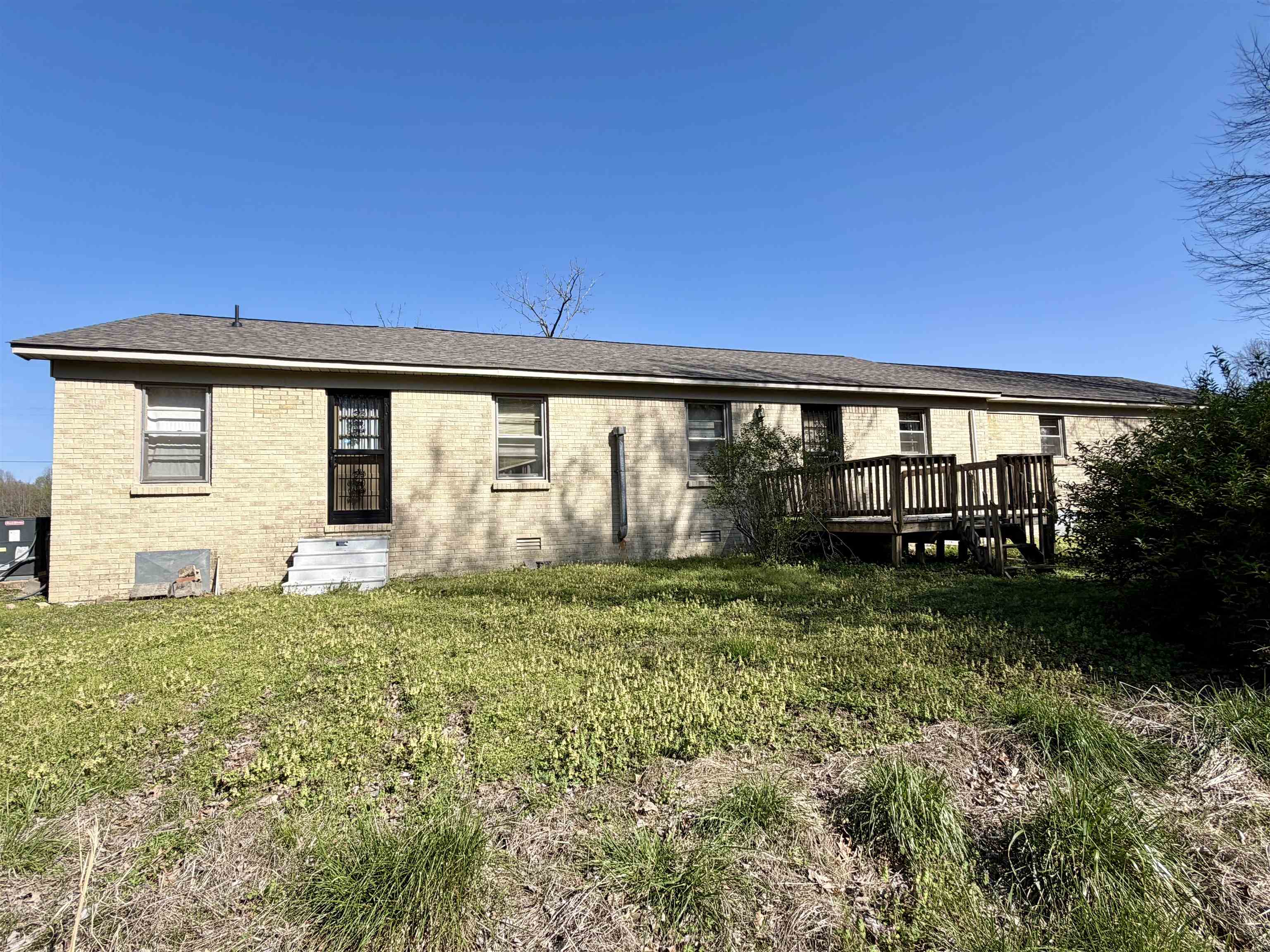 218 Sardie Henry Road Bethel Springs, TN 38315 - Photo 17 of 18 Back of property with brick siding, a yard, a wooden deck, and crawl space