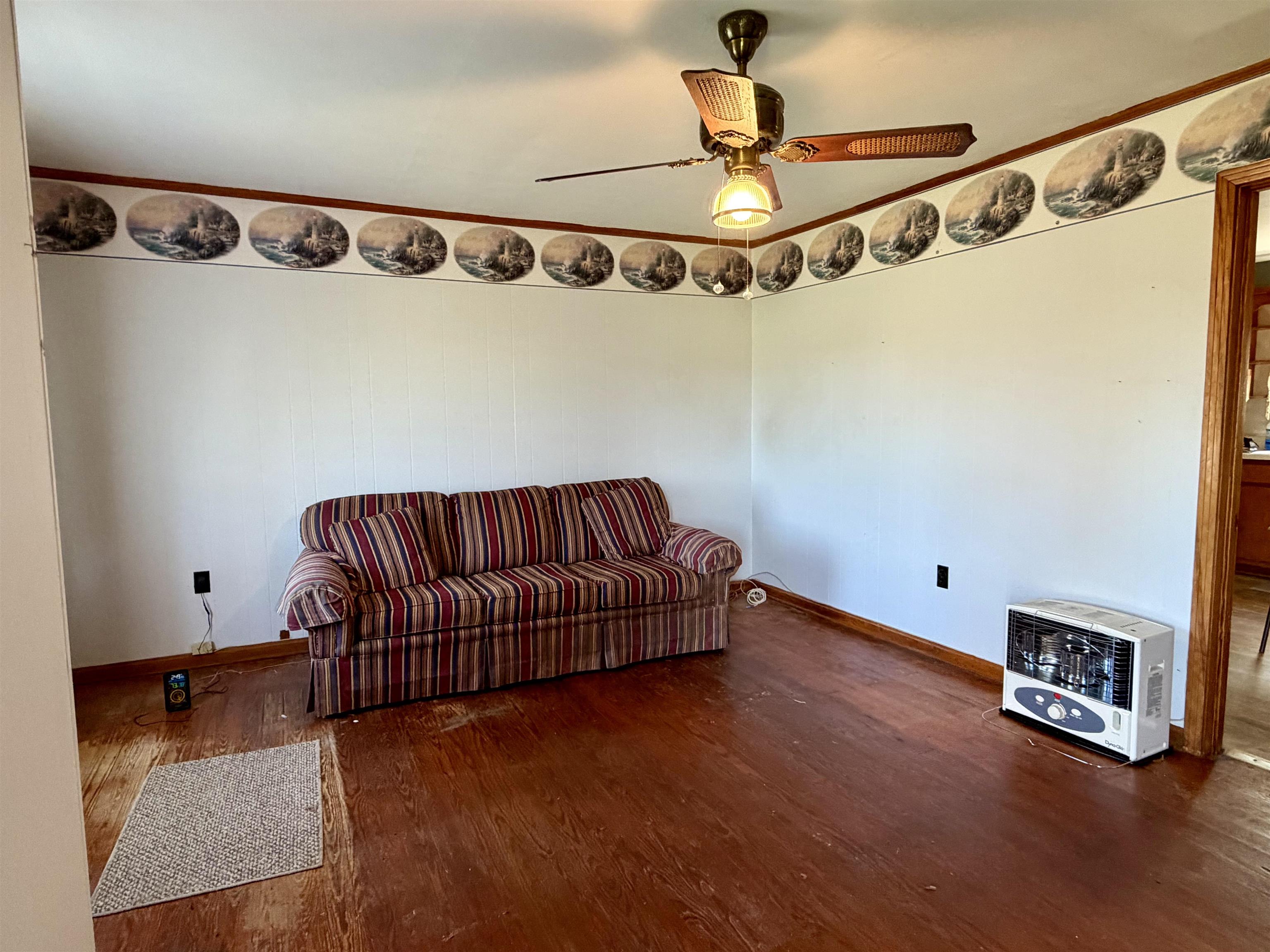 218 Sardie Henry Road Bethel Springs, TN 38315 - Photo 3 of 18 Sitting room with heating unit, dark wood-type flooring, a ceiling fan, and ornamental molding