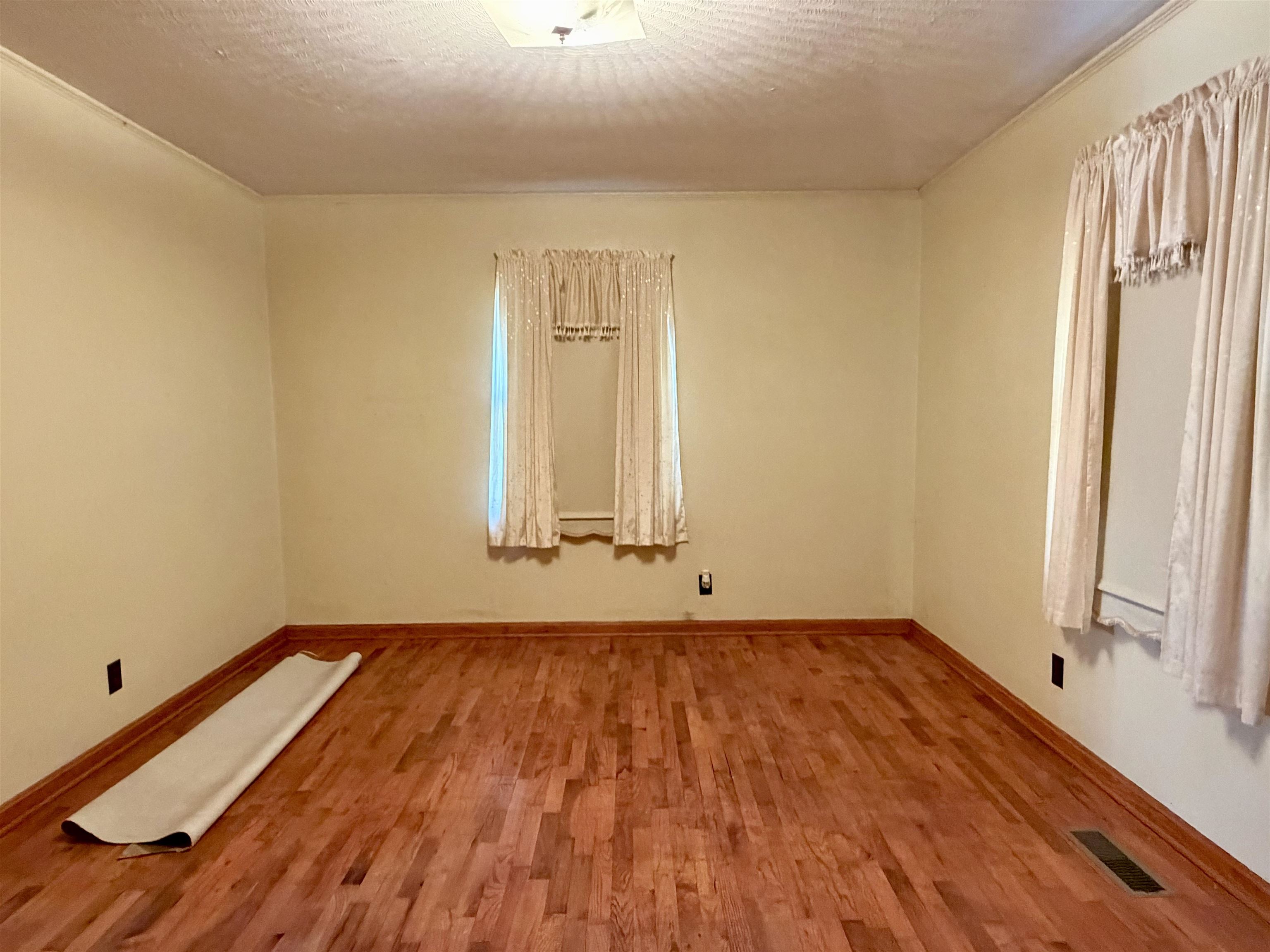 218 Sardie Henry Road Bethel Springs, TN 38315 - Photo 8 of 18 Empty room featuring wood finished floors and a textured ceiling
