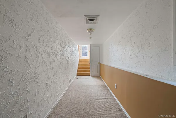 a hallway with a white wall