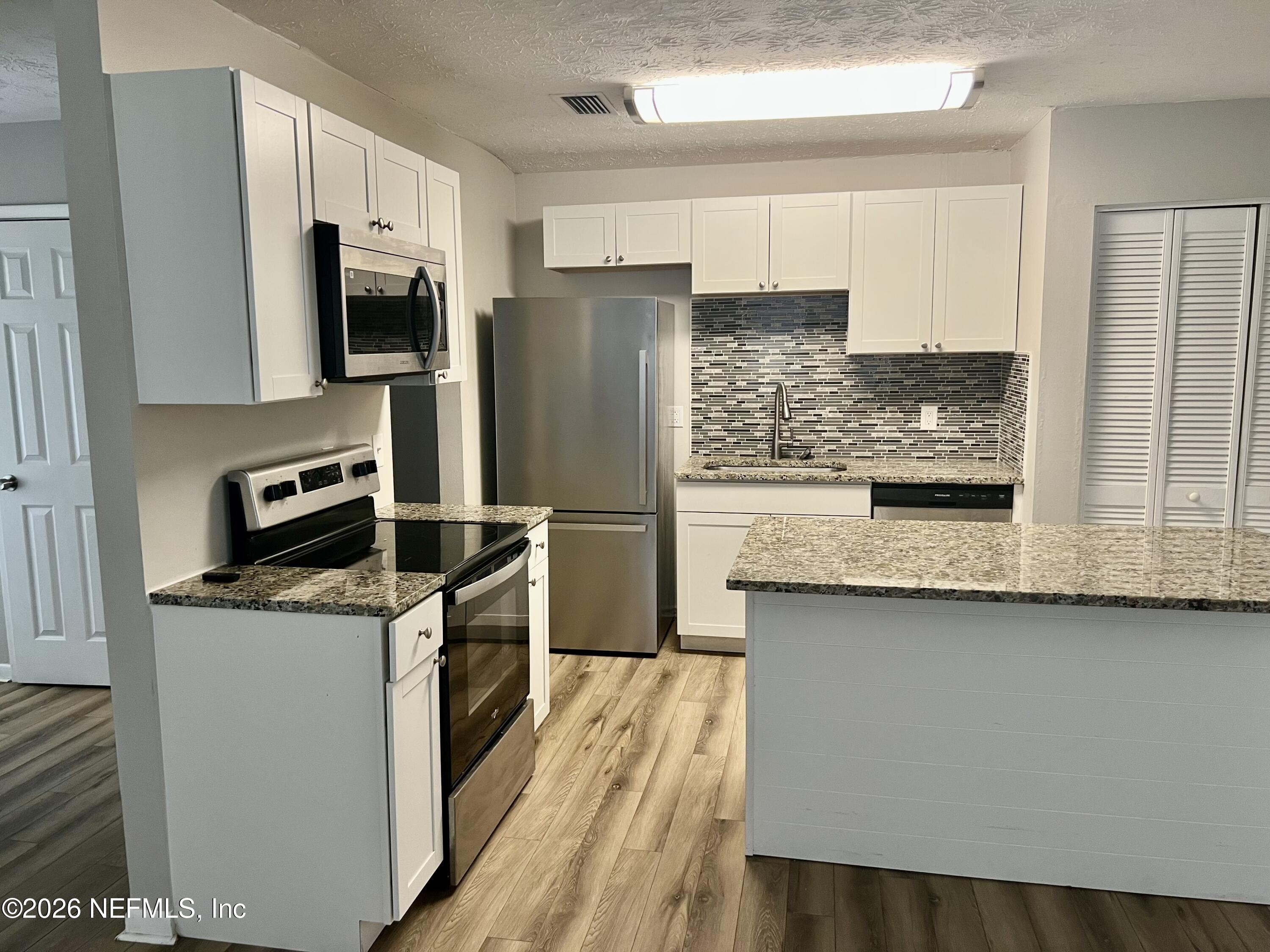10964 Bacall Road West Jacksonville, FL 32218 - Photo 8 of 19 a kitchen with stainless steel appliances granite countertop a refrigerator a stove and a sink