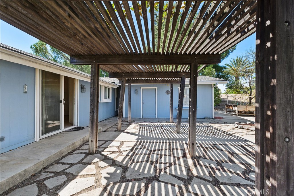 34881 Los Nogales Road Temecula, CA 92592 - Photo 14 of 50 Covered wood patio off the bvack sliding doors with view to attached garage.