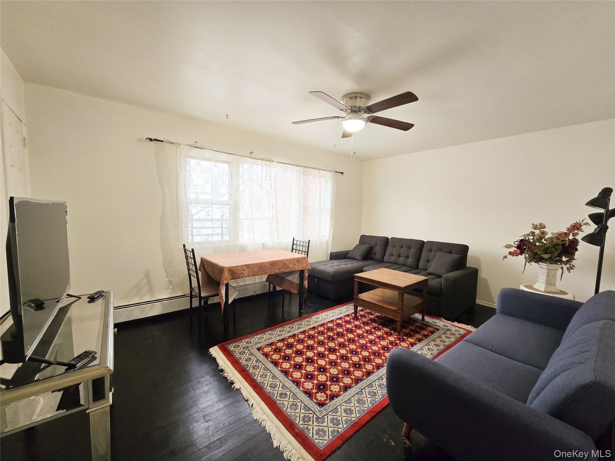 95-32 95th Street Queens, NY 11416 - Photo 13 of 20 a living room with furniture a window and a flat screen tv