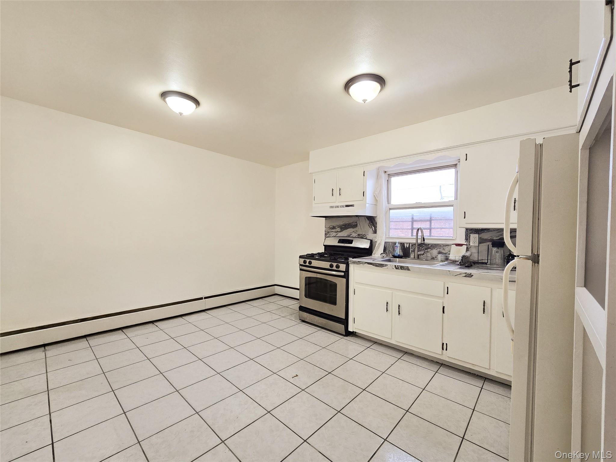 95-32 95th Street Queens, NY 11416 - Photo 14 of 20 a kitchen with granite countertop white cabinets and white appliances