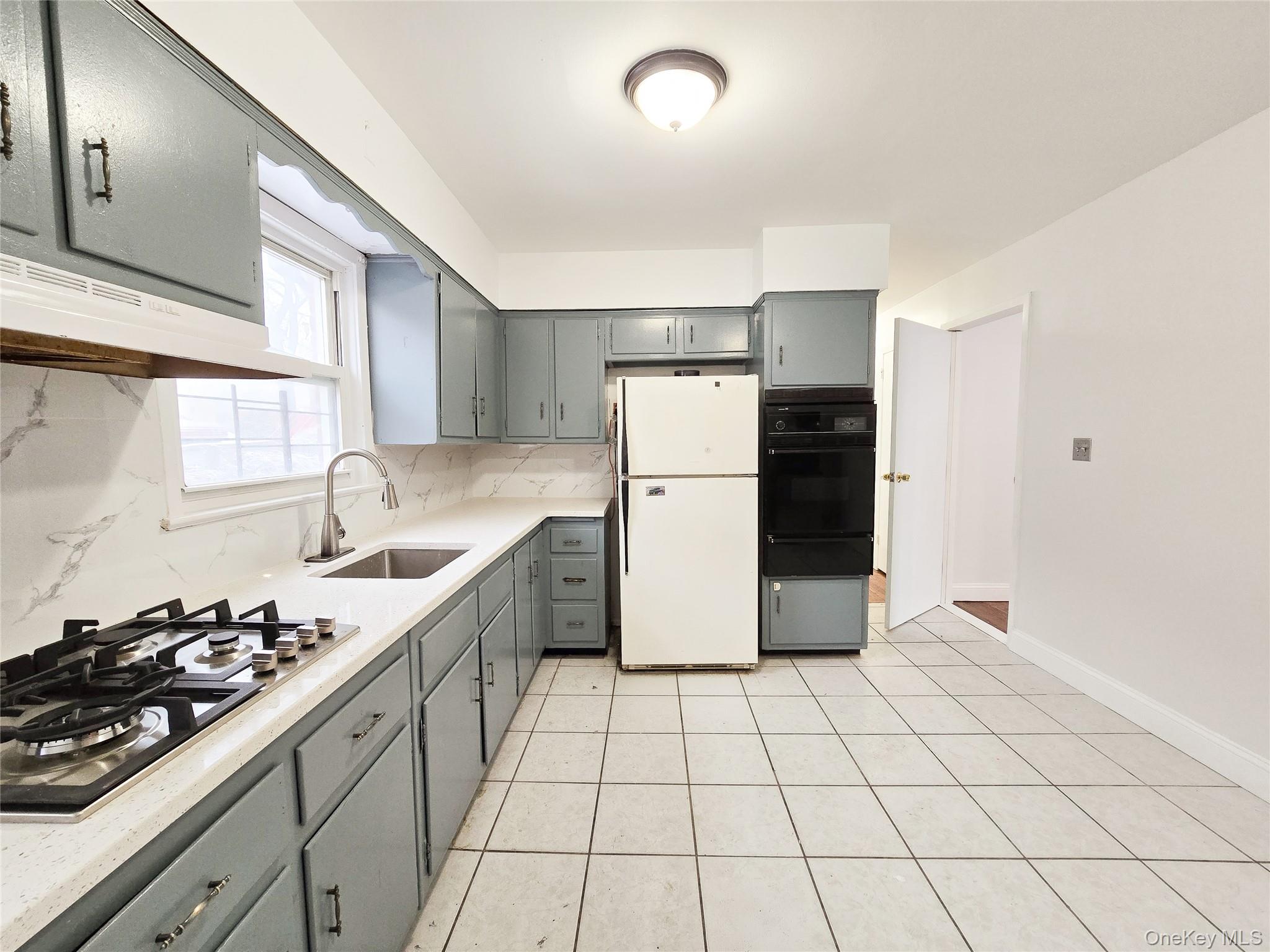 95-32 95th Street Queens, NY 11416 - Photo 17 of 20 a kitchen with a sink a refrigerator and cabinets