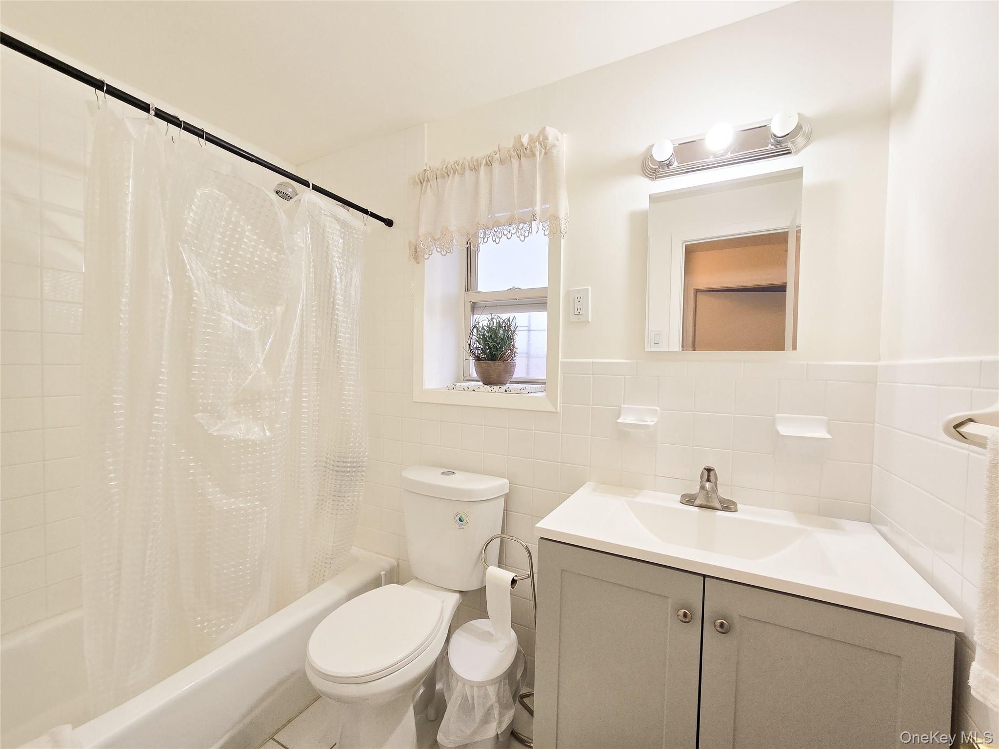 95-32 95th Street Queens, NY 11416 - Photo 6 of 20 a bathroom with a sink a toilet and shower curtain