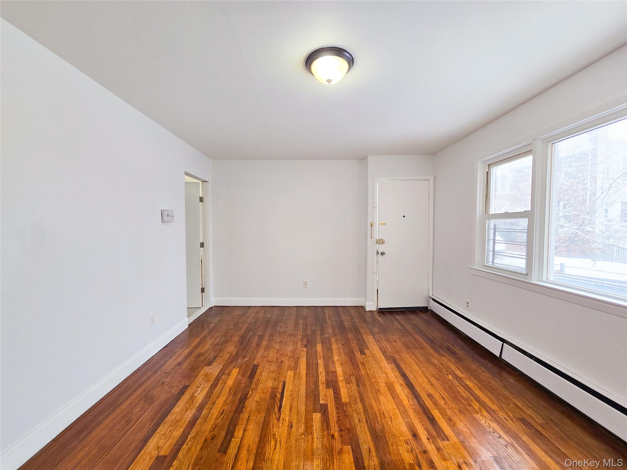 95-32 95th Street Queens, NY 11416 - Photo 7 of 20 wooden floor in an empty room with a window