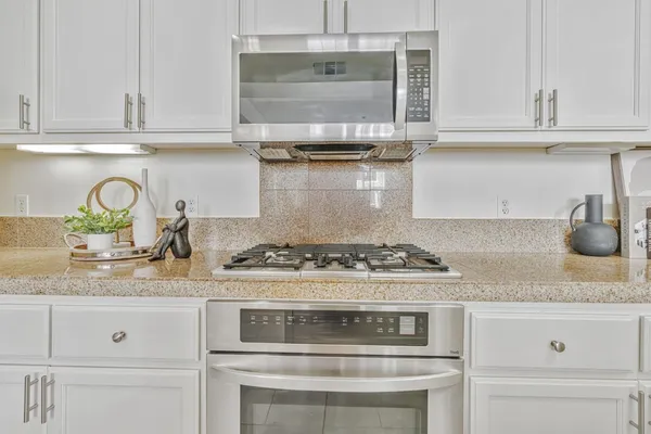 a stove top oven sitting inside of a kitchen