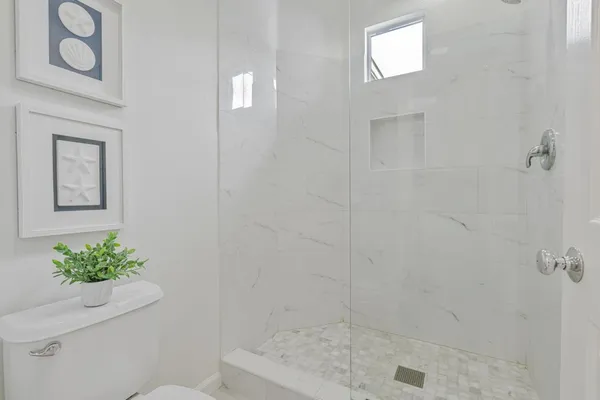 a bathroom with a shower a toilet and a sink