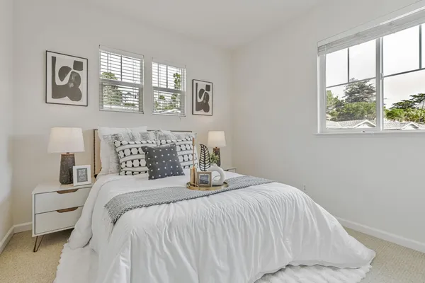a bedroom with a bed and a large window