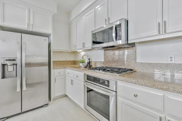 a kitchen with cabinets stainless steel appliances and a counter space