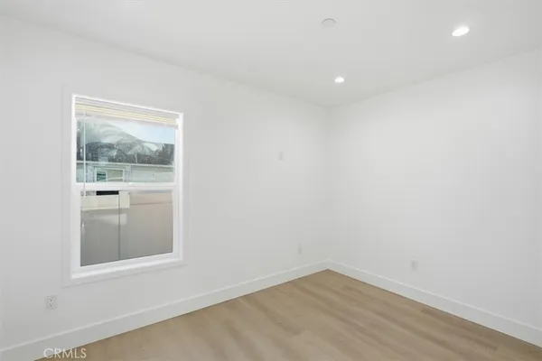 an empty room with a window and wooden floor