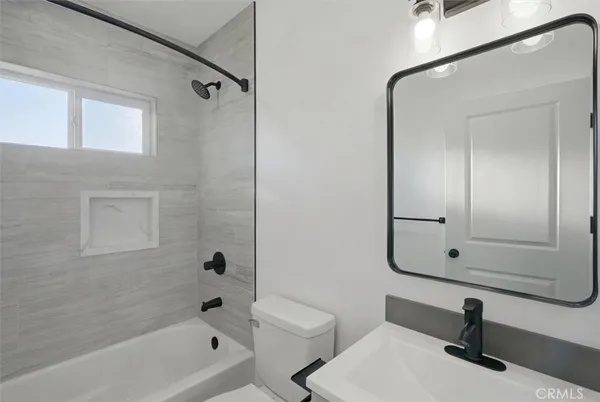 a bathroom with a bathtub shower sink and toilet