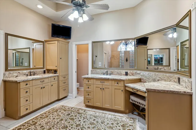 a spacious bathroom with a granite countertop double vanity sink a mirror and shower