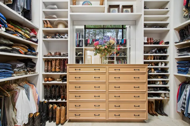 a view of walk in closet with clothes and shoes