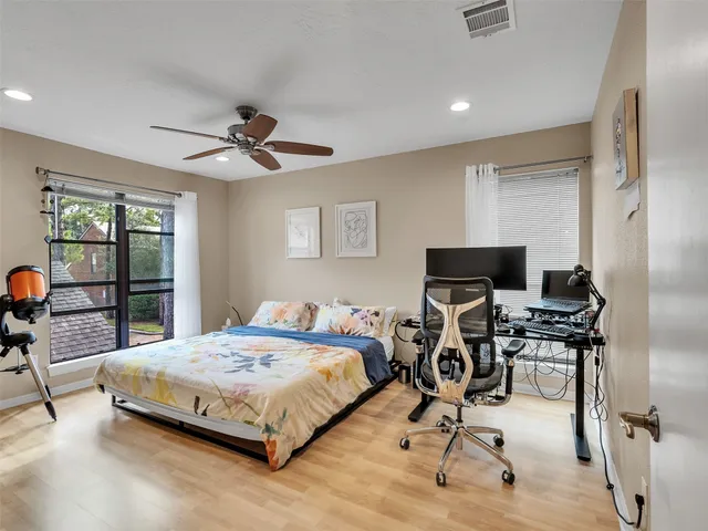 a bedroom with a bed gym equipment and a flat screen tv