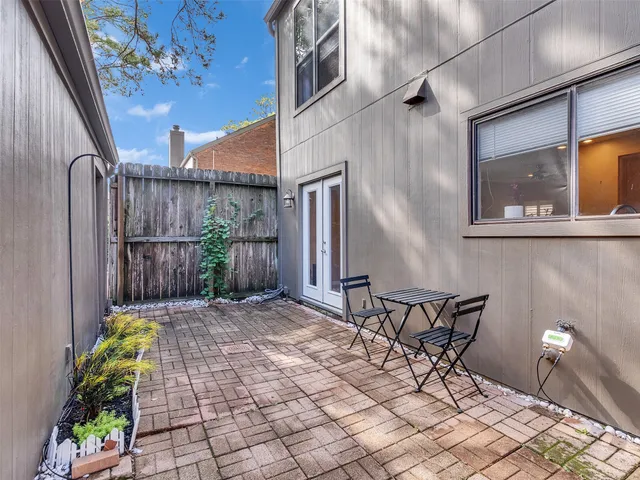 a view of backyard with a table and chairs and potted plants