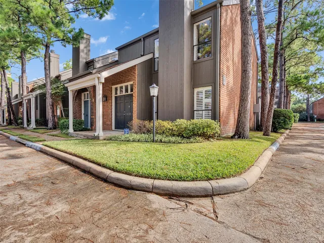 a view of a white house with a small garden