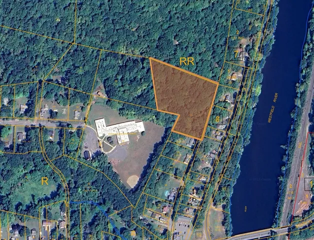 an aerial view of a house with a yard and trees all around