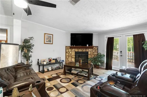 a living room with furniture a flat screen tv and a fireplace
