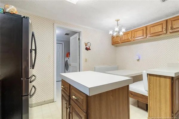 a kitchen that has a fridge and a table in it