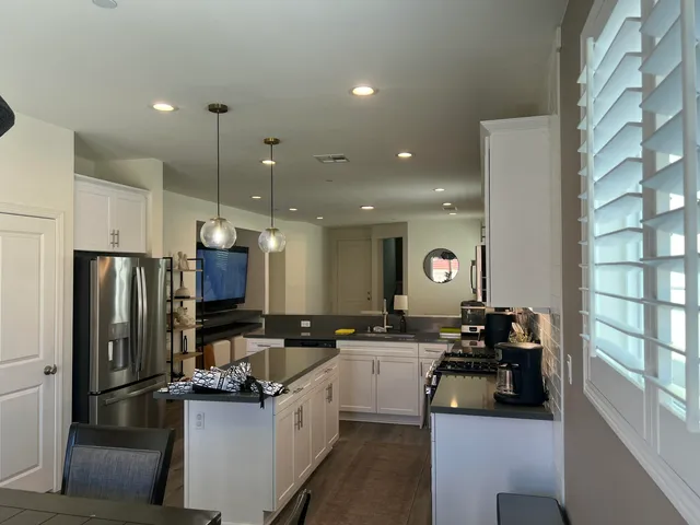 a kitchen with stainless steel appliances kitchen island granite countertop a refrigerator a sink and a stove