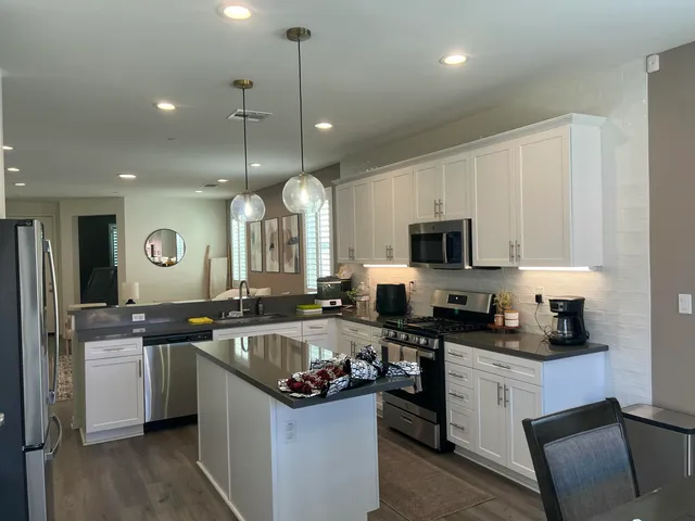 a kitchen with stainless steel appliances granite countertop a sink a stove and a refrigerator