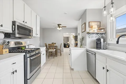 a kitchen with white cabinets and appliances
