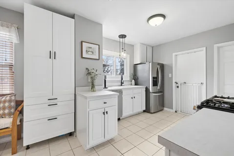 a room with white cabinets and stainless steel appliances