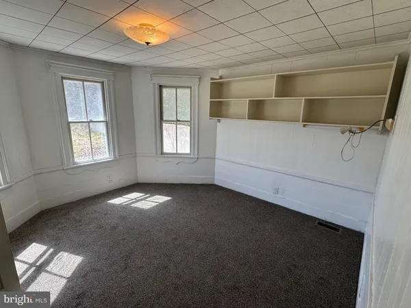 a view of room with walk in closet and wooden floor