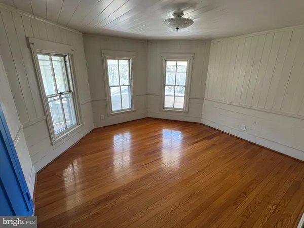 a view of a hallway with wooden floor and stairs