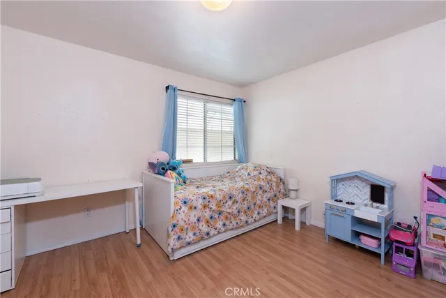 a bedroom with a bed and a wooden floor