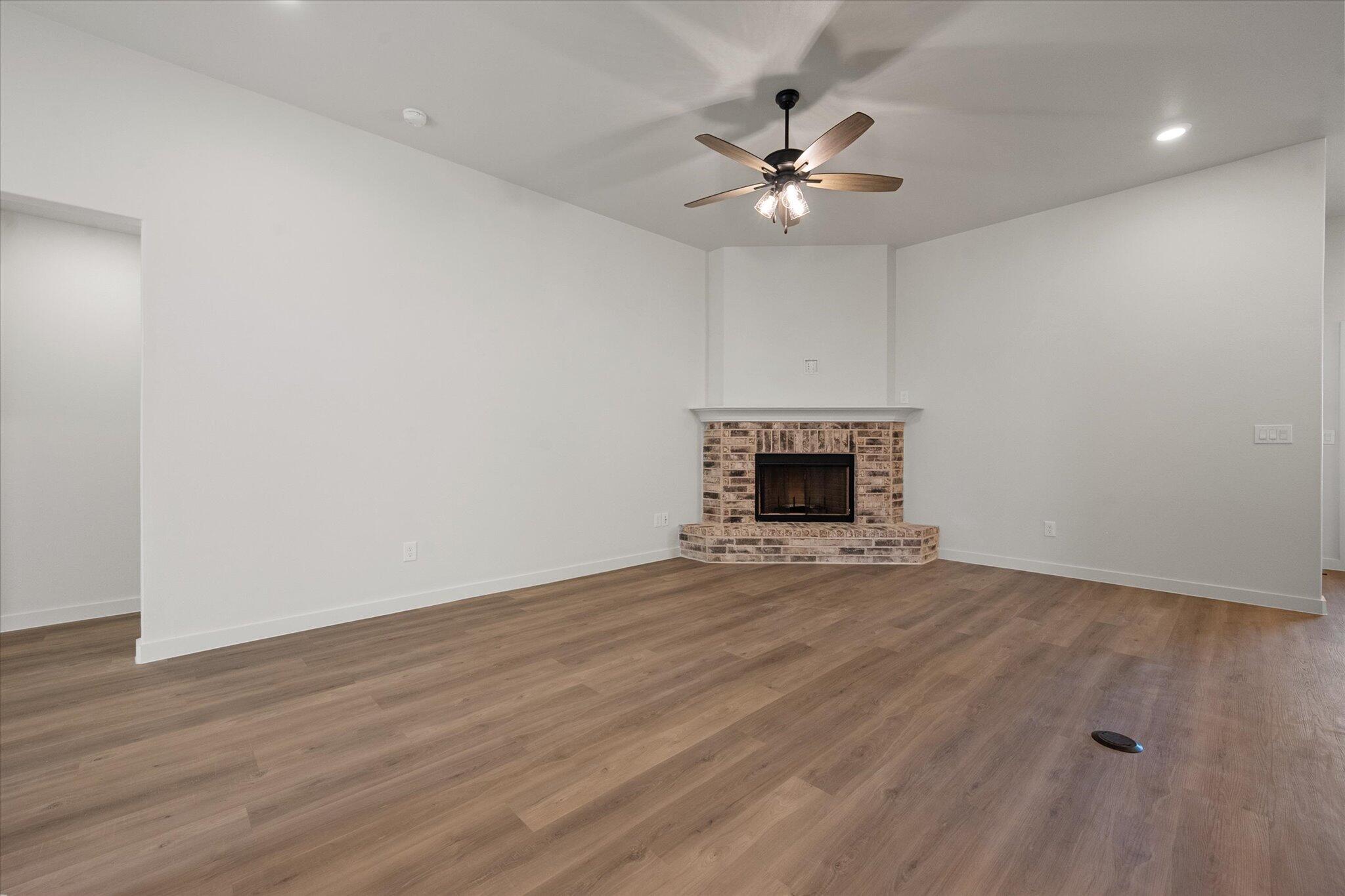 602 East 22nd Street Wolfforth, TX 79382 - Photo 4 of 22 a view of an empty room with wooden floor and a fireplace