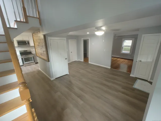 a view of empty room with wooden floor and electronic appliances