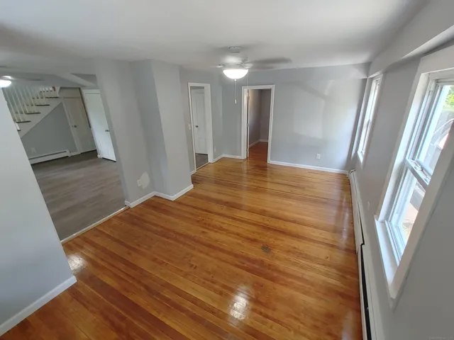 a view of empty room with wooden floor