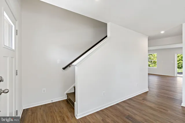 a view of hallway with wooden floor and stairs