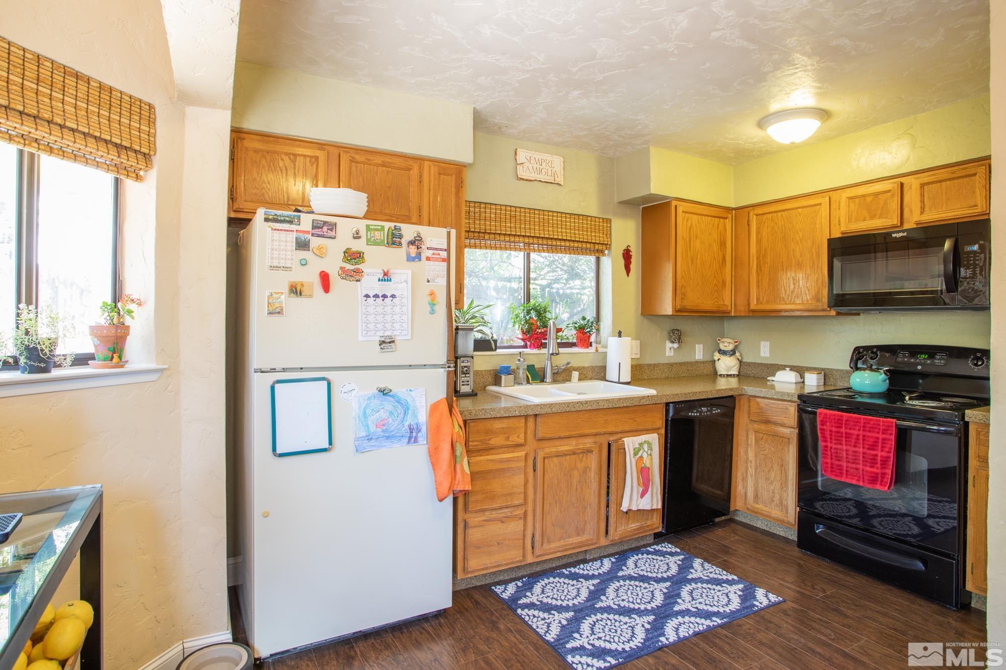 3980 Kings Row Reno, NV 89503 - Photo 11 of 35 a kitchen with stainless steel appliances granite countertop a stove a sink and a microwave