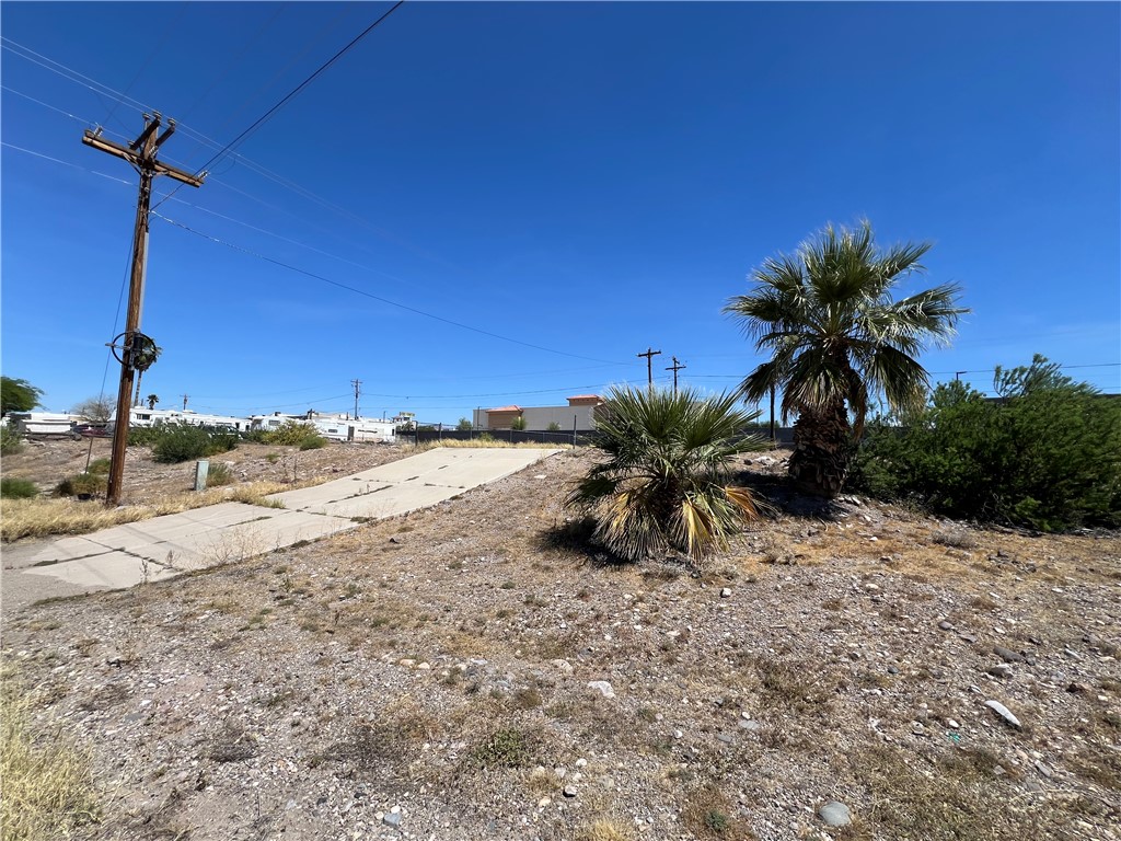 1692 Shamrock Road Bullhead City, AZ 86442 - Photo 3 of 11 The property features a clear, blue sky overhead and includes two distinct palm trees