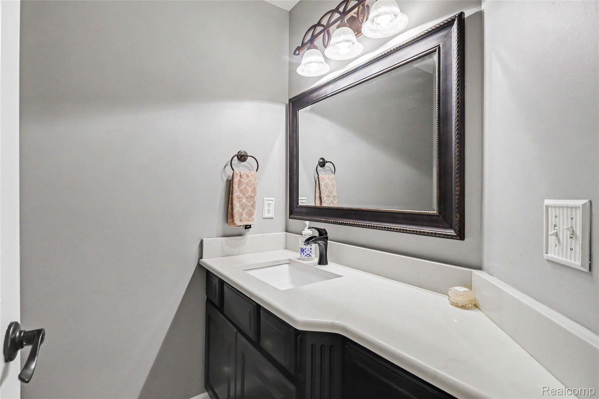 2548 Empire Court Rochester, MI 48309 - Photo 32 of 40 Bathroom vanity featuring a vessel sink, dark wood-finish cabinetry, and a light-toned countertop