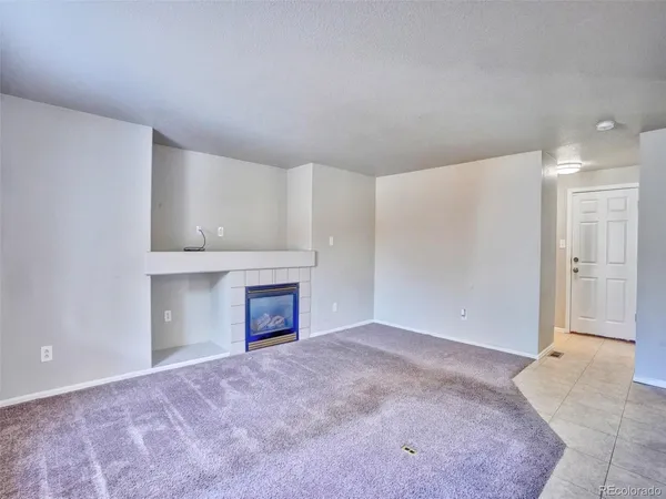 a view of an empty room with a fireplace and a window