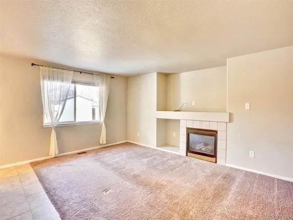 an empty room with a fireplace and windows