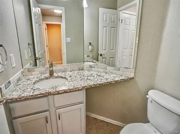 a bathroom with a granite countertop sink and a mirror