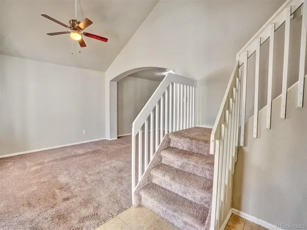 a view of staircase with a ceiling fan and wooden floor