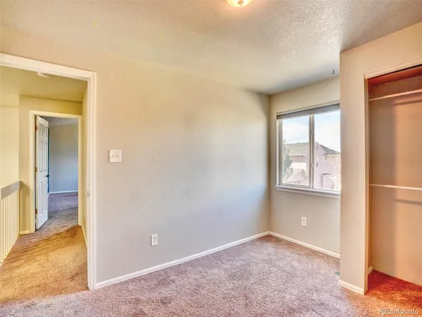 an empty room with windows and closet