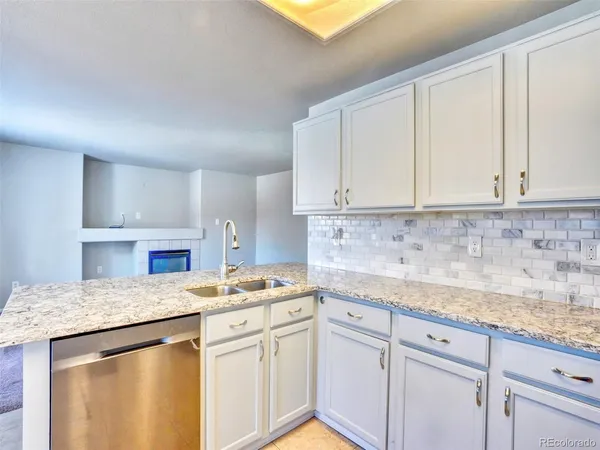 a kitchen with granite countertop white cabinets and white appliances