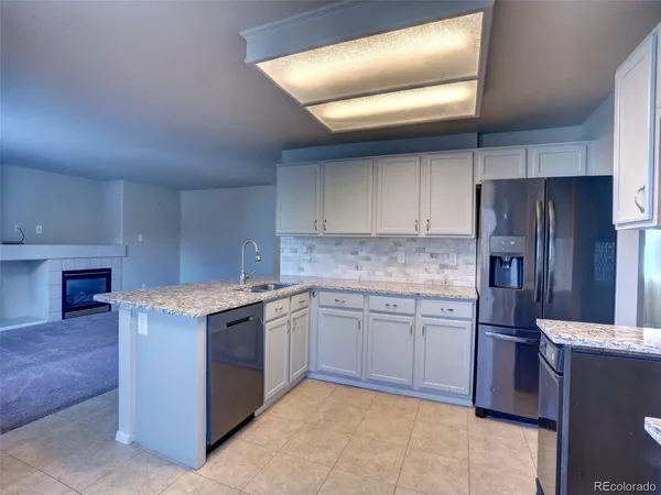a kitchen with stainless steel appliances granite countertop a refrigerator and a stove